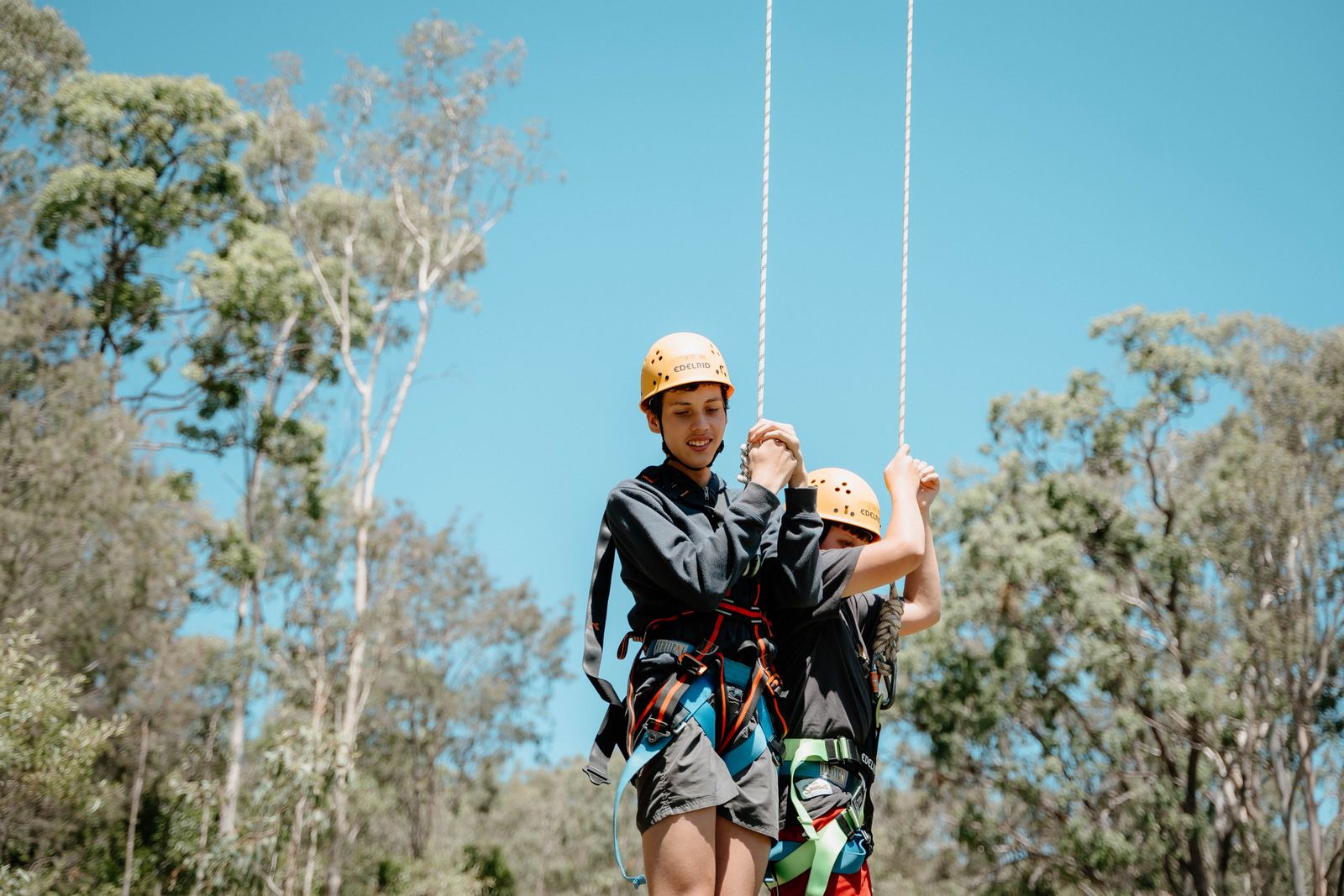 Student in a harness and helmet on the giant swing