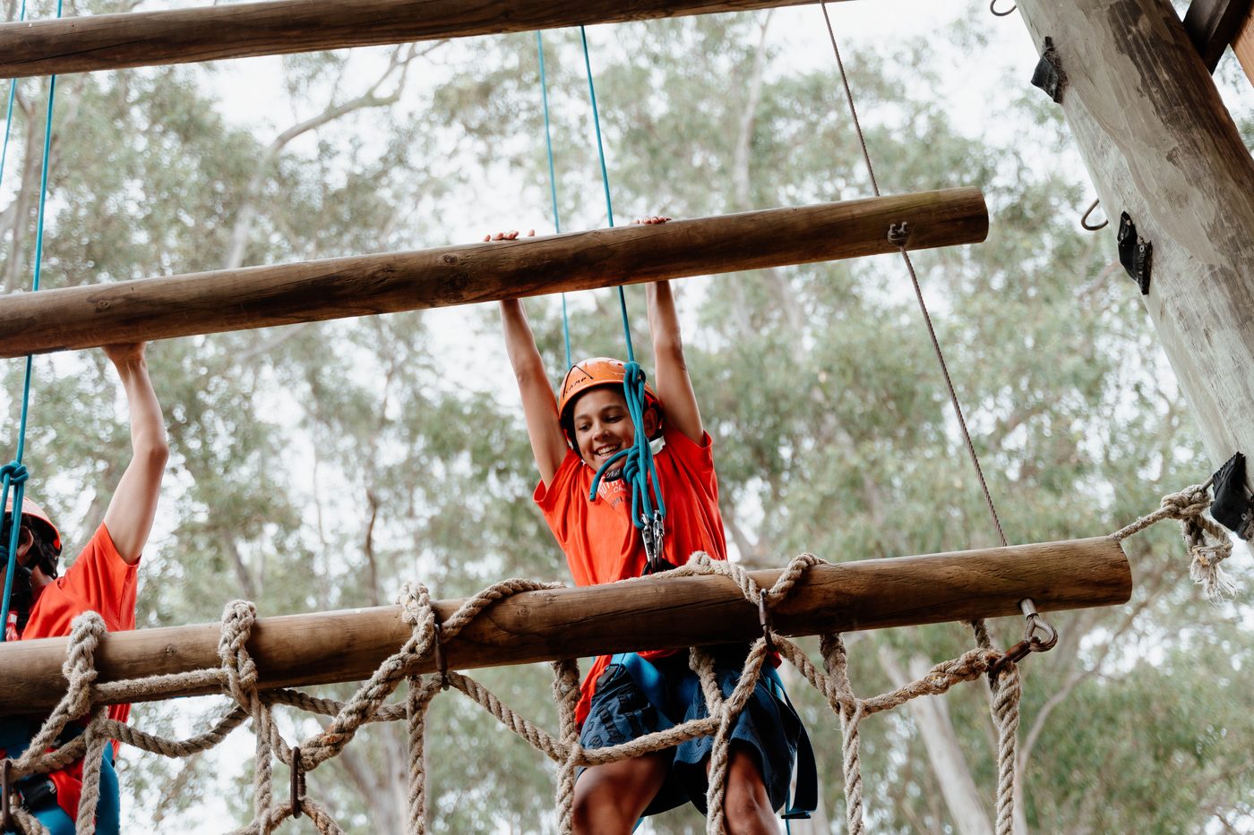 Student in a helmet crossing the high ropes course